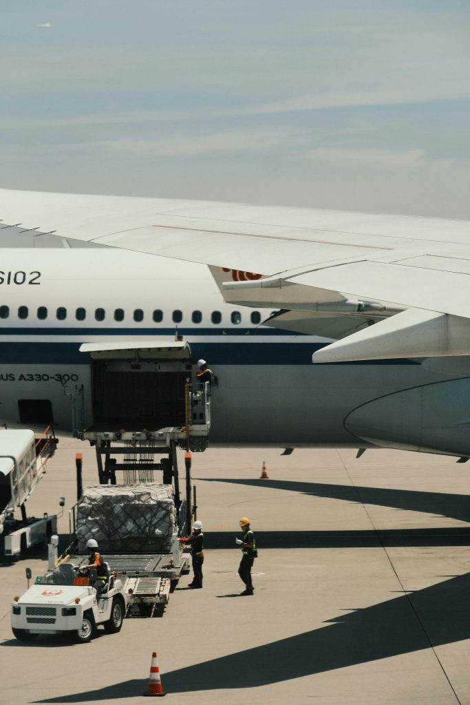 Un Airbus A330 est chargé de fret sur une piste d'aéroport, illustrant la logistique des transports.